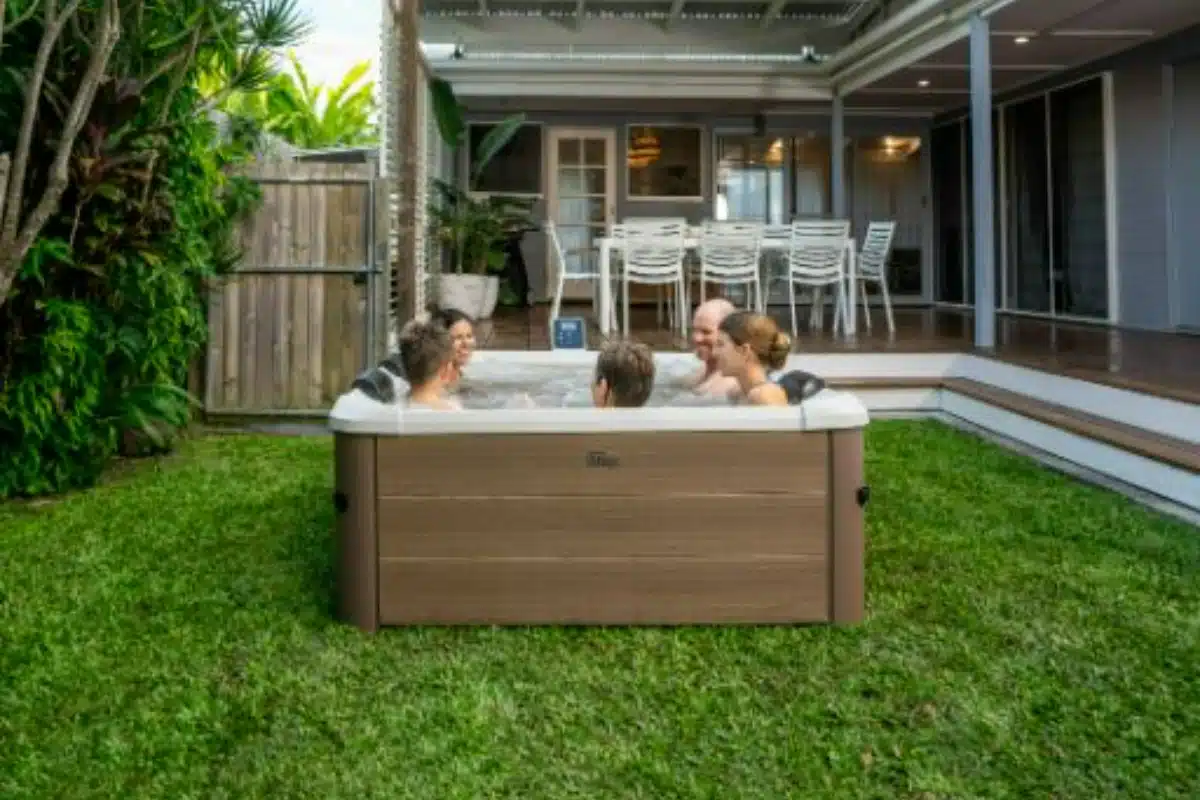 Group of people enjoying the convenience of MSpa Oslo Amber in the garden area of their home.